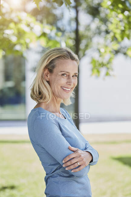 Портрет улыбающейся блондинки в парке — стоковое фото