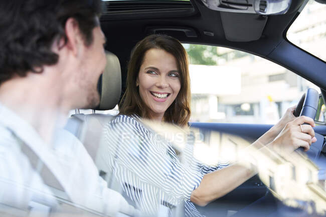 Счастливая пара в машине с женщиной за рулем — стоковое фото