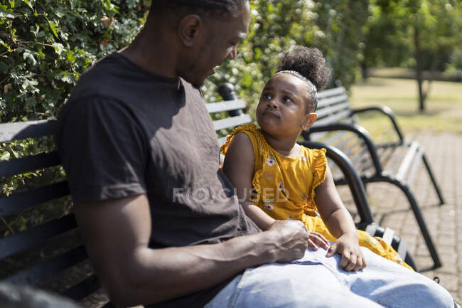 Padre e hija sentados en un banco en un parque — cuidado, Sentada - Stock  Photo | #467041032