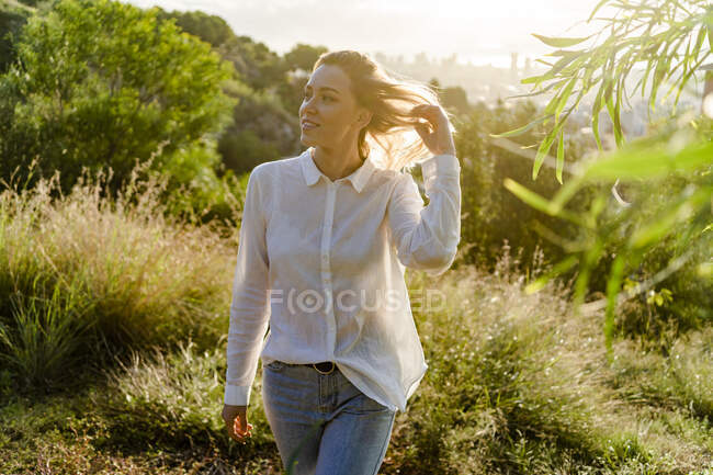 Young woman walking above the city at sunrise, Barcelona, Spain — Stock Photo