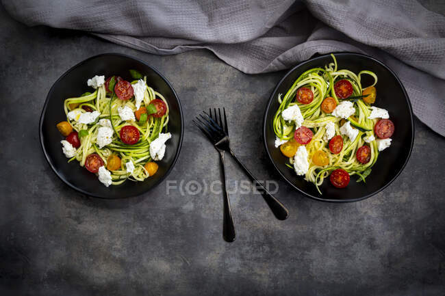 Directly above shot of vegetable salad served in bowls with forks by napkin on table — Stock Photo