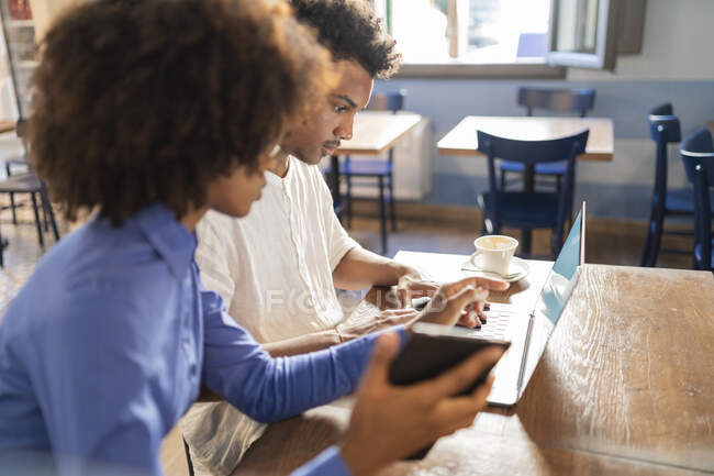 Students using laptop for a project in a cafe — Stock Photo