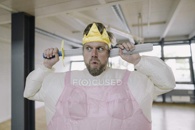 Uomo vestito da ballerina con spada giocattolo in ufficio — Foto stock
