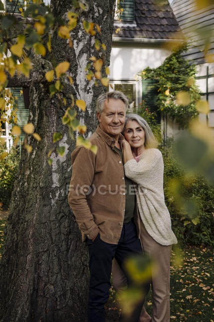 Senior couple in garden of their home in autumn — Stock Photo