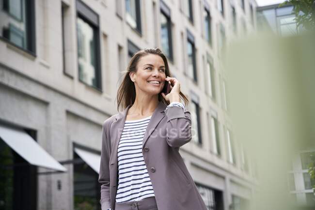 Glückliche Geschäftsfrau am Telefon in der Stadt — Stockfoto