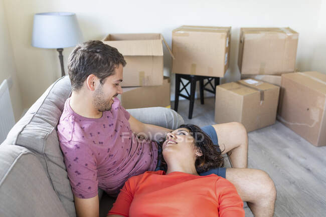 Happy couple relaxing on couch in new home — Stock Photo