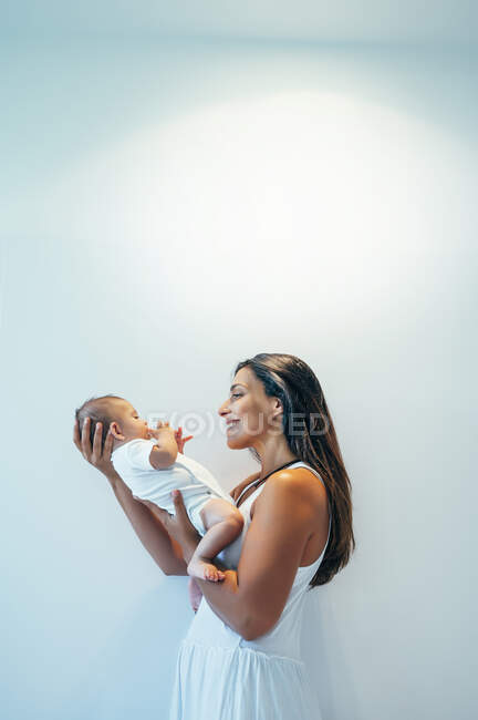 Sorridente madre tenendo il suo bambino in casa — Foto stock