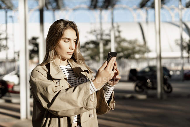 Молодая блондинка использует смартфон и делает селфи — стоковое фото