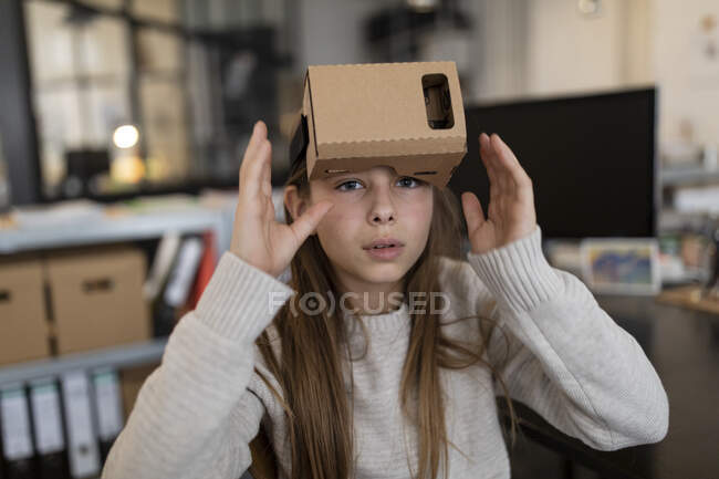 Girl with cardboard VR glasses in office — Stock Photo