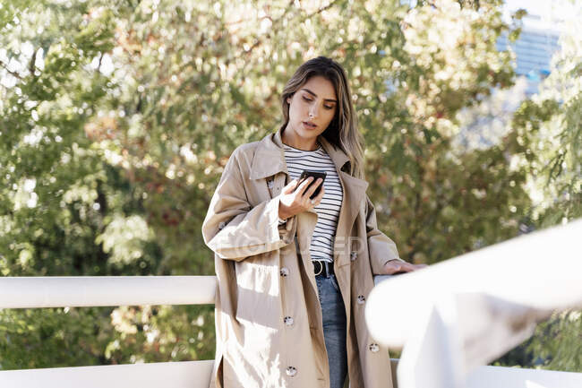 Mujer rubia joven usando teléfono inteligente - foto de stock
