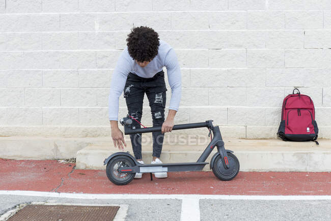 Young man folding e-scooter — Stock Photo