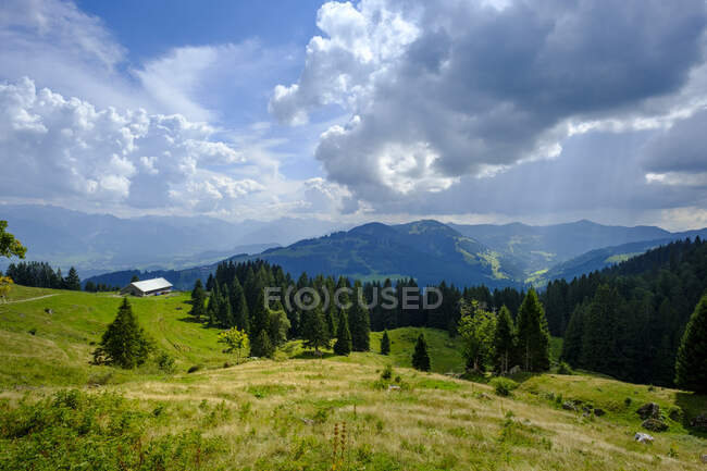 Alemania, Baviera, Nubes sobre cabaña aislada en los Alpes Allgau - foto de stock