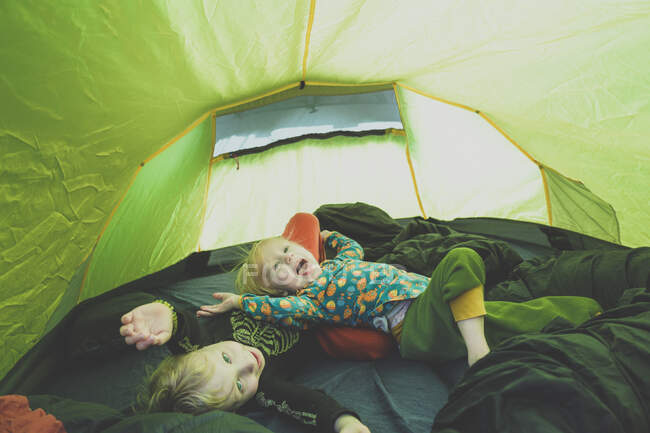 Frères et sœurs jouant ensemble dans une tente — Photo de stock