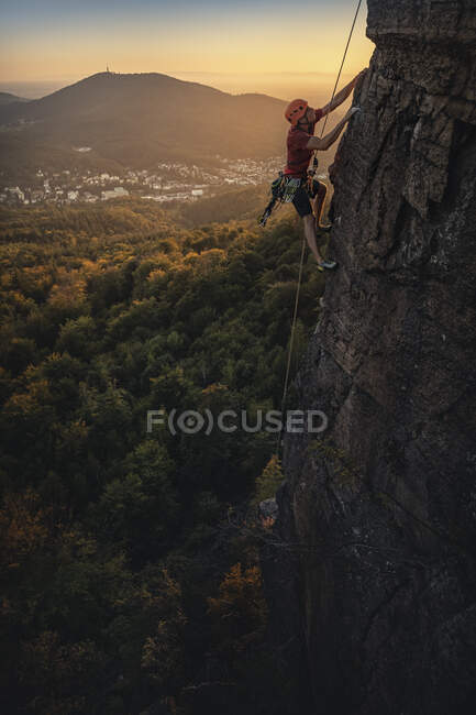 Hombre escalando en la roca Battert al atardecer, Baden-Baden, Alemania - foto de stock
