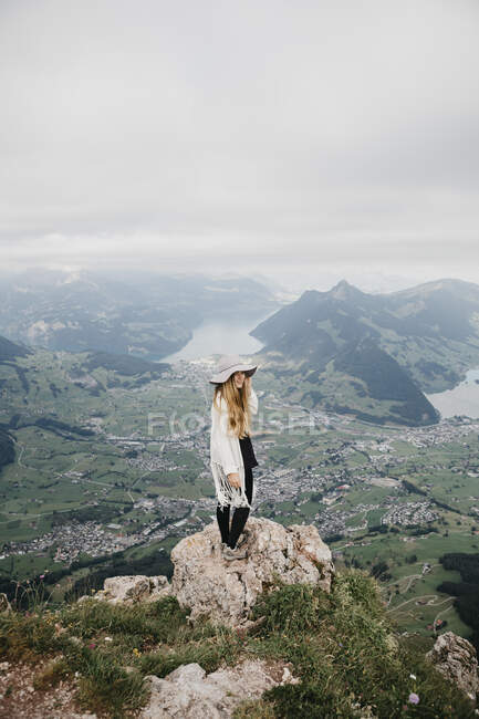 Молодая женщина в шляпе, стоящая на смотровой площадке, Гроссер Митен, Швейцария — стоковое фото