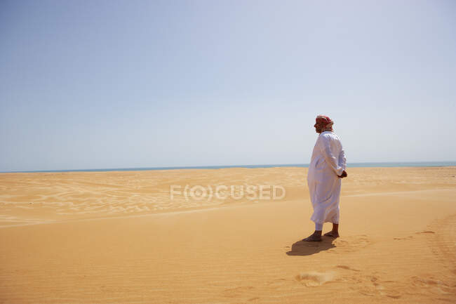 Бедуїн у національному вбранні, що стоїть у пустелі, задній вид, Вахіба Сендс, Оман — стокове фото