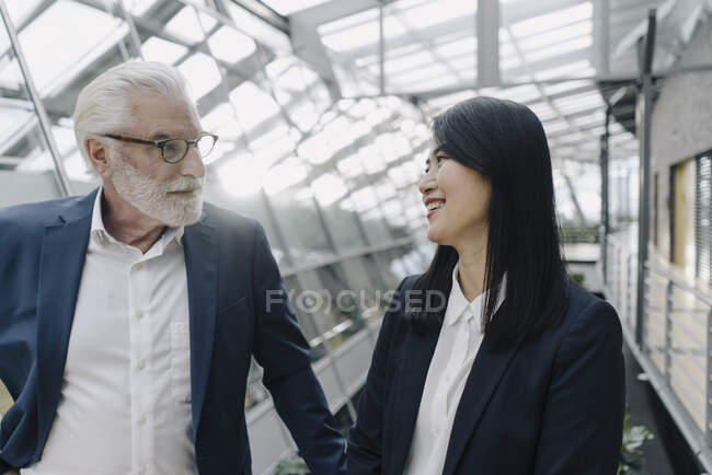 Senior-Geschäftsfrau und lächelnde Geschäftsfrau in modernem Bürogebäude — Stockfoto