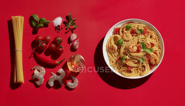 Pasta di gamberetti in ciotola acquistare vari ingredienti su sfondo rosso — Foto stock