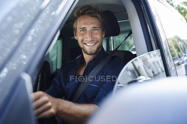 Портрет усміхненого молодого чоловіка в машині. — стокове фото