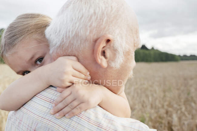 Nipote abbracciare il nonno all'aperto — Foto stock