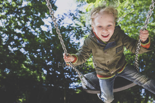 Портрет щасливого маленького хлопчика на гойдалці — стокове фото