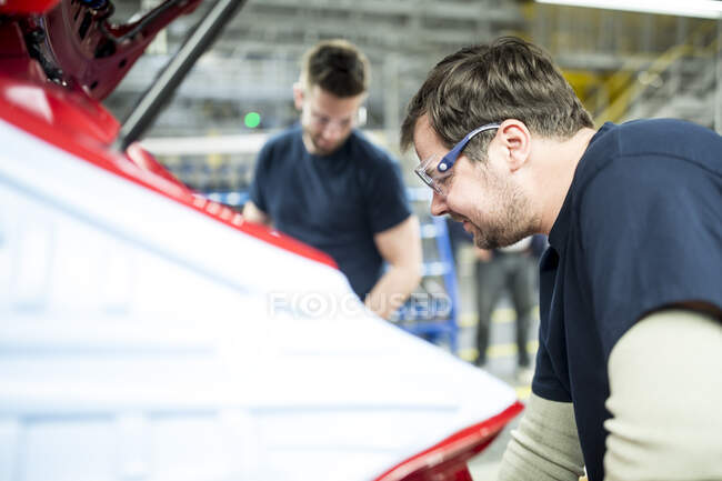 Two colleagues working in modern car factory — Stock Photo