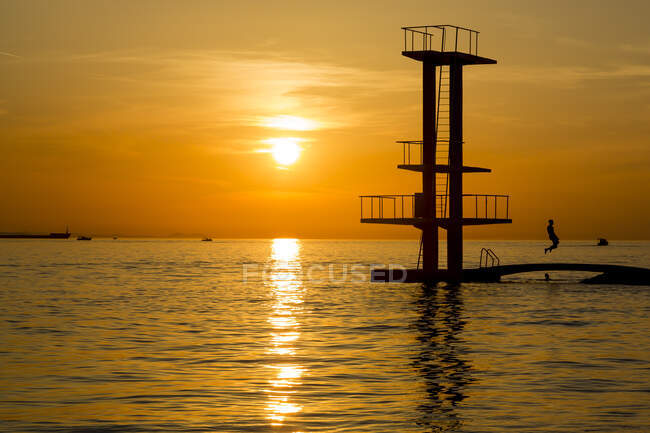 Croácia, Zatar, Silhueta da plataforma de mergulho costeiro ao pôr do sol — Fotografia de Stock
