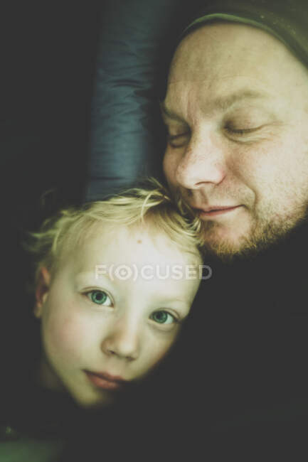 Портрет маленького мальчика и его отца, лежащих в палатке — стоковое фото