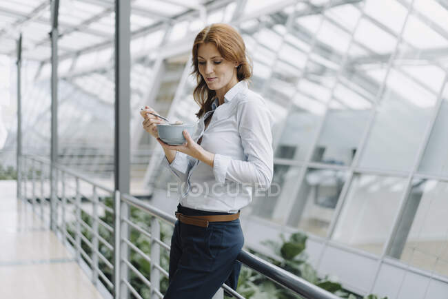 Безробітна жінка перестала їсти муеслі в сучасному офісному будинку. — стокове фото