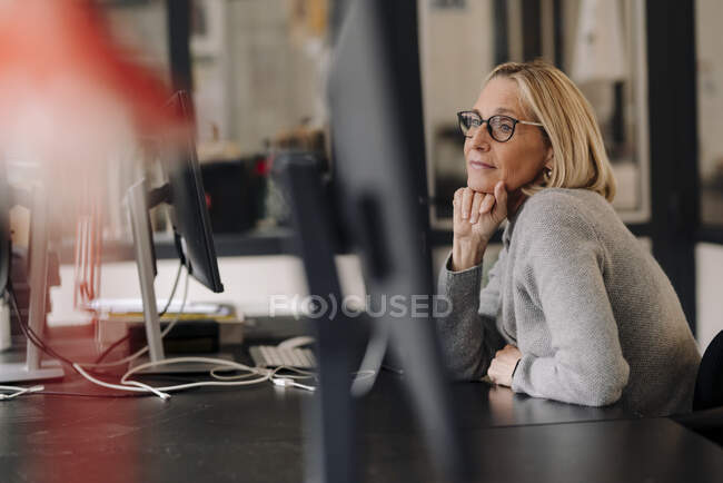 Reife Geschäftsfrau sitzt am Schreibtisch im Büro — Stockfoto