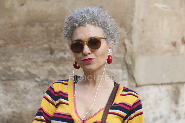 Retrato de mujer madura perforada con auriculares - foto de stock