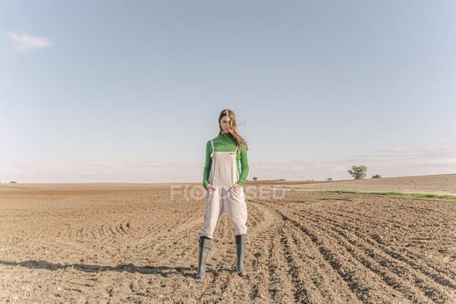 Молода жінка стоїть на сухому полі — стокове фото