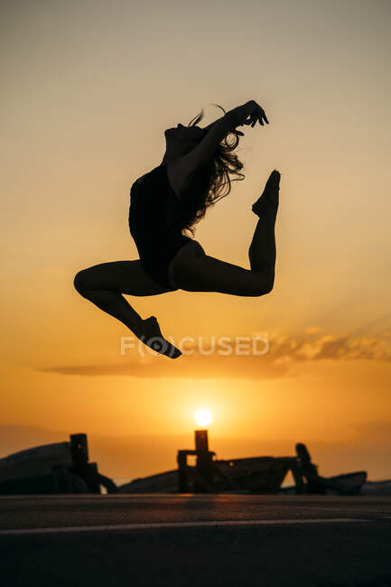 Silhouette of ballerina daning at sunset — Stock Photo