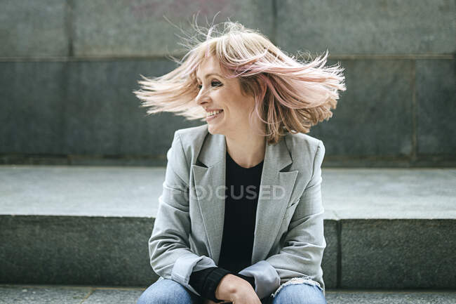 Mulher feliz movendo seu cabelo rosa — Fotografia de Stock