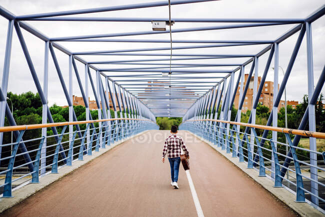 Chico gitano con guitarra caminando por el puente - foto de stock
