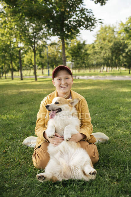 Мальчик с валлийским Корги Пемброком в парке — стоковое фото