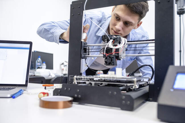 Studente che imposta la stampante 3D, utilizzando il computer portatile — Foto stock