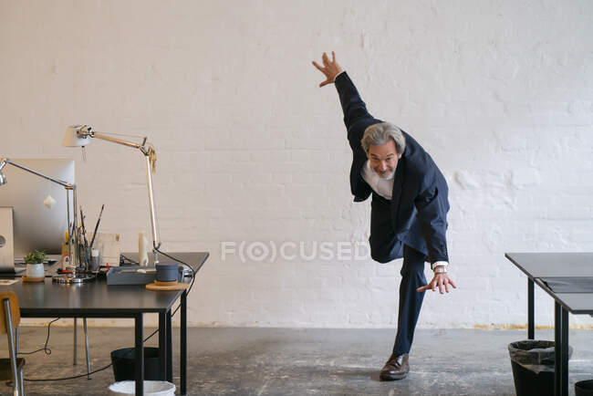 Uomo d'affari senior che fa ginnastica in ufficio — Foto stock