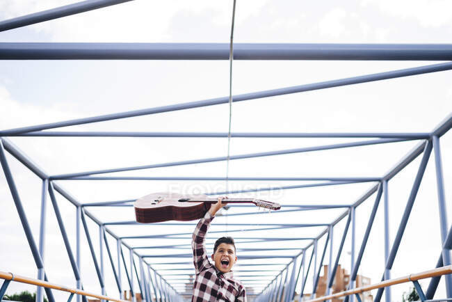 Gypsy boy with guitar on a bridge — Stock Photo