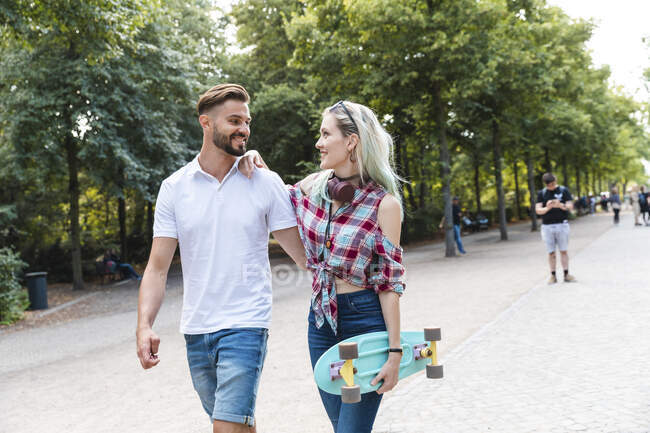 Feliz joven pareja caminando en un parque - foto de stock