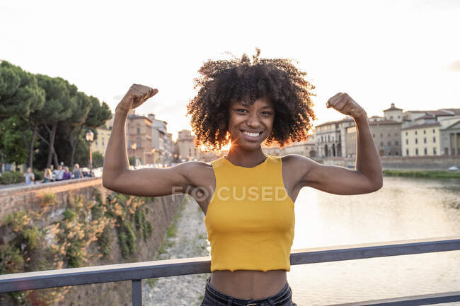 Portrait of happy young woman posing on a bridge above river Arno at sunset, Florence, Italy — Stock Photo