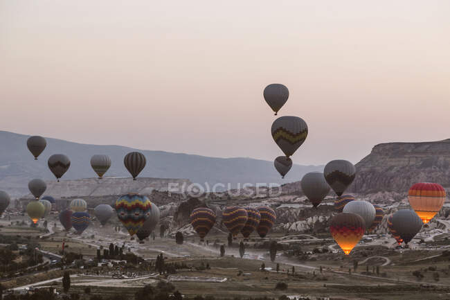 Colorful hot air balloons flying over landscape against clear sky at Goreme National Park, Cappadocia, Turkey — Stock Photo