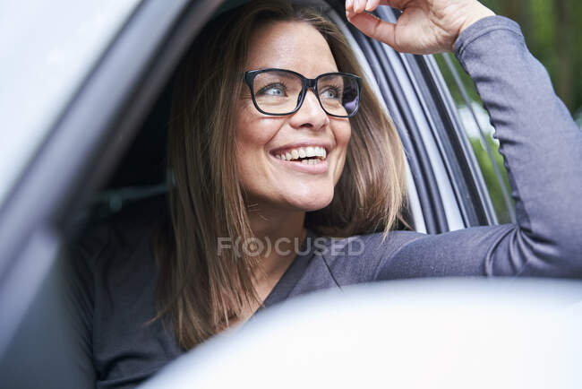 Portrait de femme souriante dans une voiture — Photo de stock