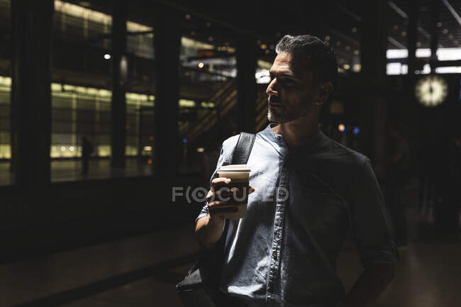 Чоловік з кавою на вокзалі в тіні — стокове фото