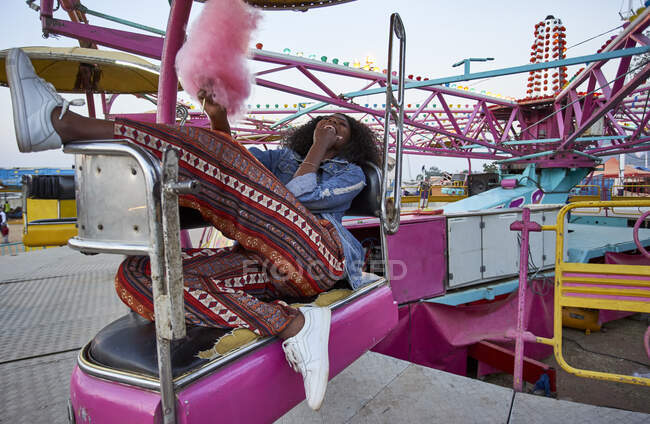 Laughing young woman with pink candyfloss at fair — Stock Photo