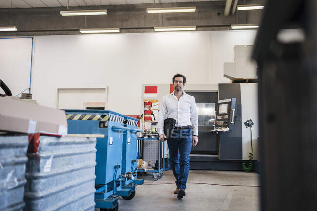 Empresario caminando en una fábrica - foto de stock