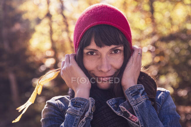 Женщина в красной шерстяной шляпе и джинсовой куртке — стоковое фото