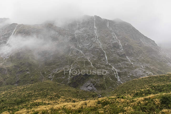 Nouvelle-Zélande, Océanie, Île du Sud, Southland, Parc national de Fiordland, Pluie continue créant des chutes d'eau à flanc de montagne — Photo de stock