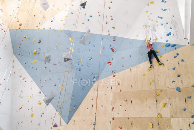 Donna arrampicata sulla parete in palestra di arrampicata — Foto stock