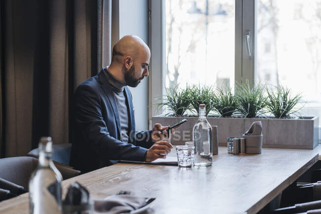 Geschäftsmann mit Smartphone im Café — Stockfoto
